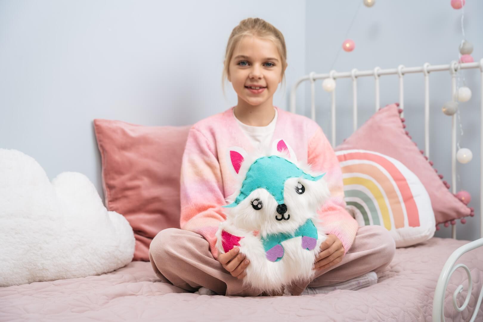 Dziewczynka prezentuje uszytego pluszowego liska z zestawu WOW BOX