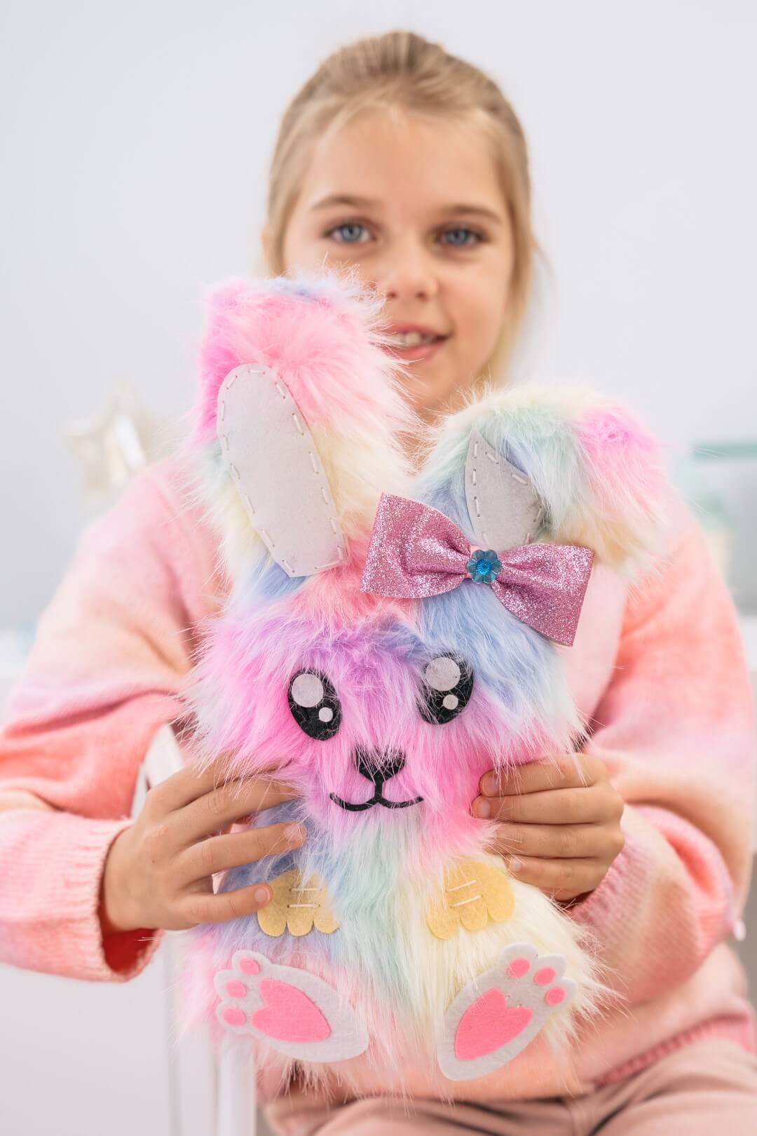 Dziewczynka trzyma gotowego pluszowego króliczka z zestawu WOW BOX